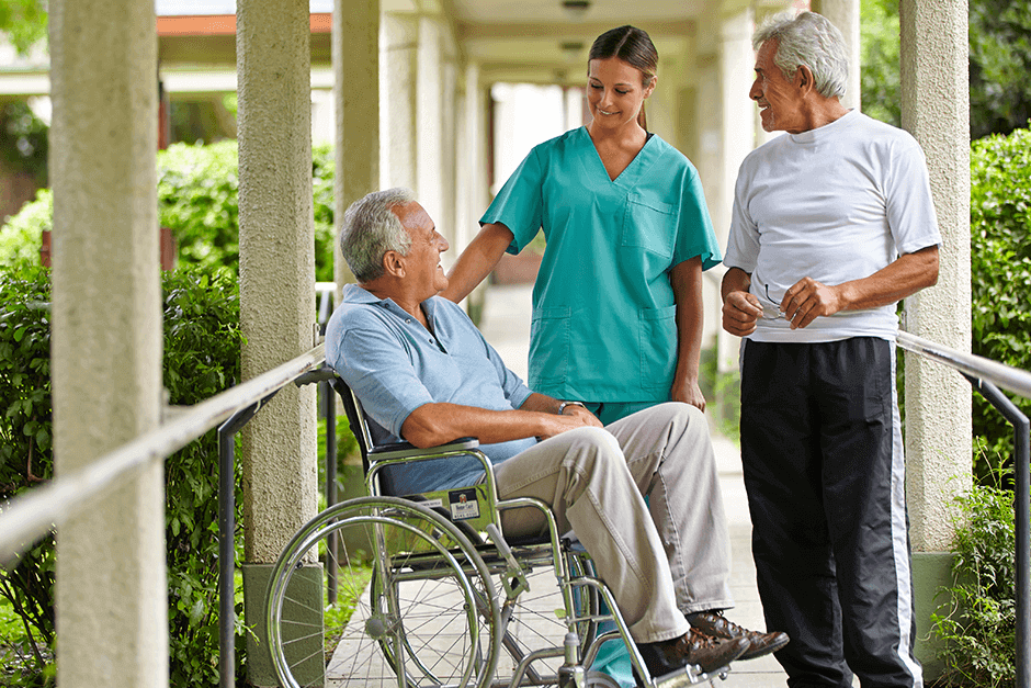 A man in a wheelchair talking to two people.