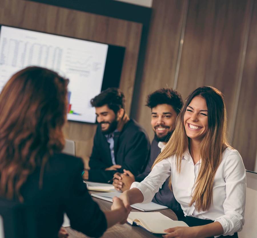 Business meeting with handshake and smiles.