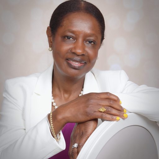 A woman sitting in a chair wearing a white jacket.