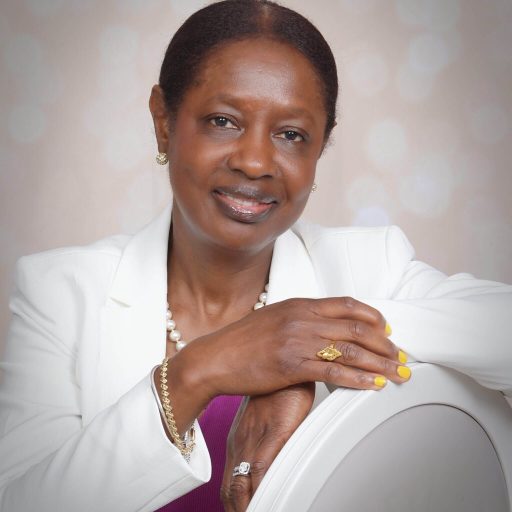 A woman sitting in a chair wearing a white jacket.